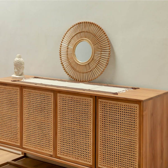Handgefertigter Boho Rattanspiegel BUMI, 58 cm Durchmesser, an einer Holzkommode in modernem Raum