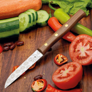 Gemüsemesser Zöppken mit Holzgriff auf einer Holzplatte, umgeben von frischem Gemüse und Tomaten.