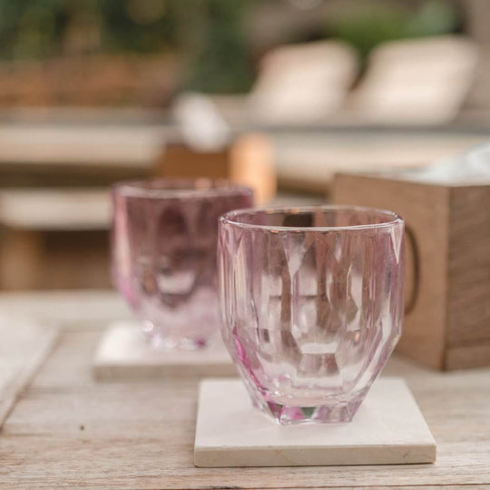 Handgefertigte Marmor-Untersetzer mit eleganten, pinken Trinkgläsern auf einem Holztisch. Ideal für Esstisch-Dekoration.