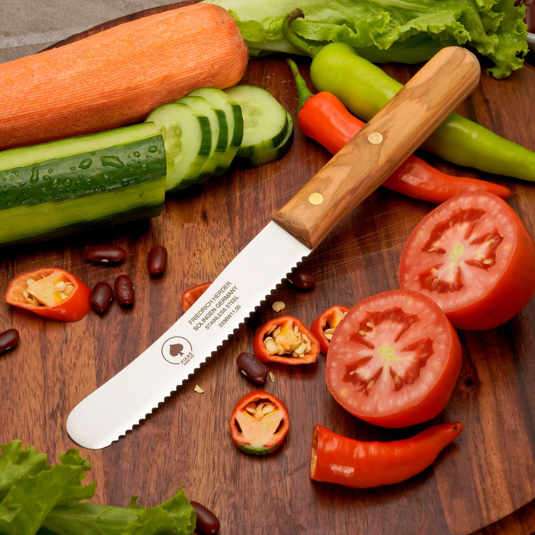 Buckelsmesser aus Solingen auf einem Schneidebrett mit frischem Gemüse und Tomaten.