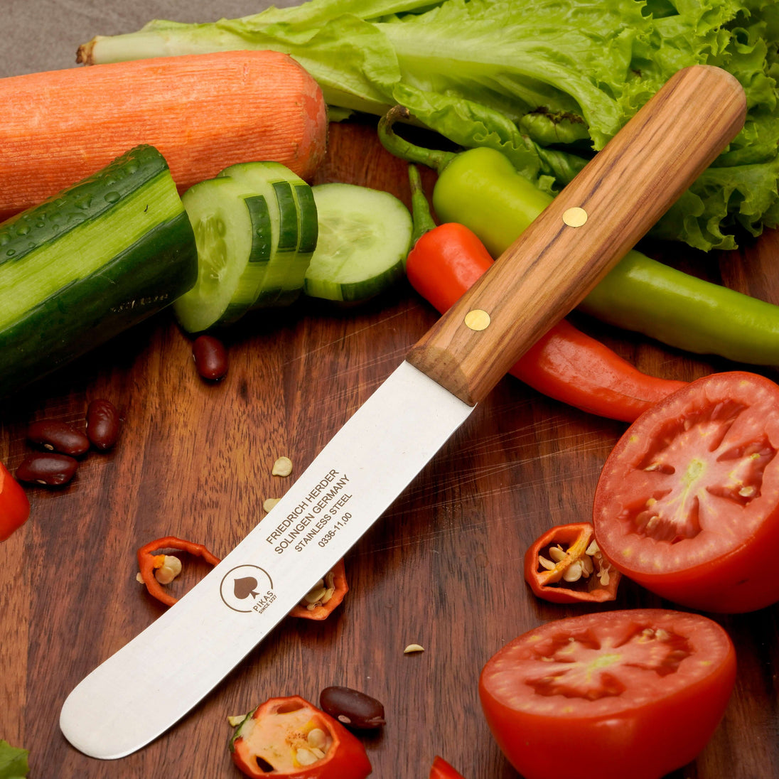 Buckelsmesser aus Solingen mit Holzgriff, ideal für das Frühstück, um Gemüse zu schneiden, auf einem Holzbrett.