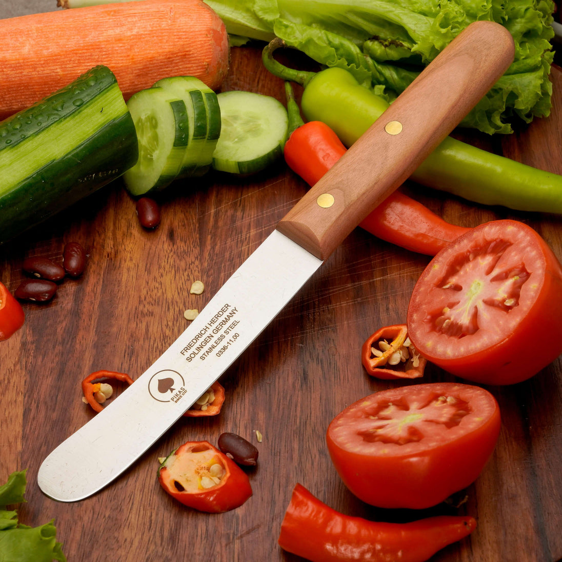 Buckelsmesser Solingen auf Holztisch mit frischem Gemüse, ideal für Frühstück und Küchenarbeiten.
