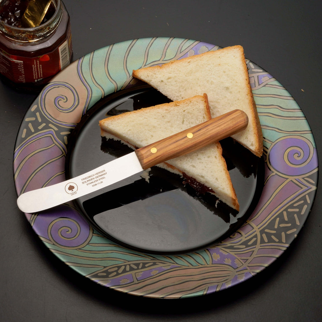 Natürliches Buckelsmesser auf farbigem Teller mit Toastscheiben und Marmelade.