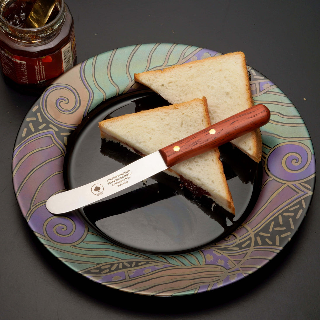 Buckelsmesser auf einem Teller mit Sandwichscheiben, ideal für Frühstück und Marmelade.