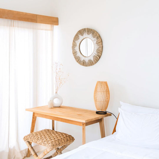 Handgefertigter Runder Wandspiegel aus Seegras im Boho-Stil in einem minimalistischen Schlafzimmer