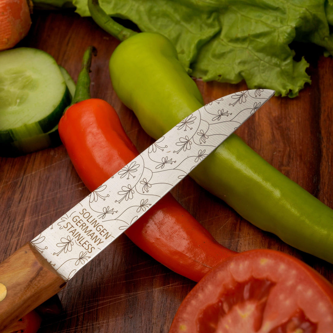 Gemüsemesser Zöppken Style mit rostfreier Klinge und Holzgriff, umgeben von frischem Gemüse.